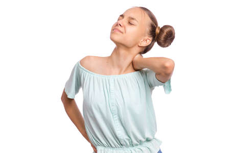 Unhappy teen girl suffering from backache, isolated on white background. Cute young teenager hands touching back and neck pain. Upset child massaging his back suffering from discomfort ache pain.の写真素材