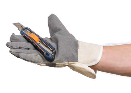 Male Hand wearing Working Glove with Office knife. Human Hand holding Stationery Knife Cutter, Isolated on White Background.の写真素材