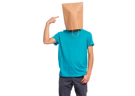 Portrait of teen boy pointing finger at paper bag over head, isolated on white background. Child posing in studio.の写真素材