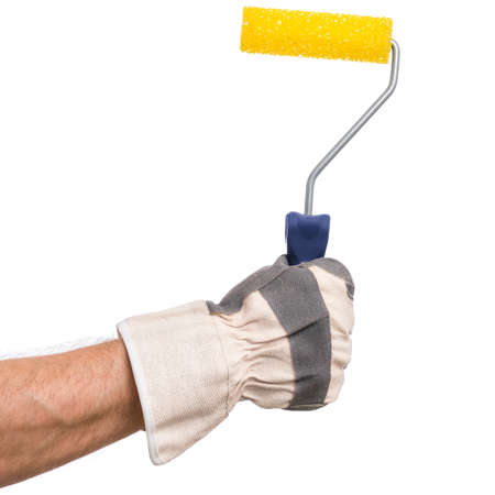 Close up view of Worker Man Hand with Paint Roller Brush. Male Hand wearing Working Glove with Tools. Human hand holding new Roller, isolated on white background.の写真素材