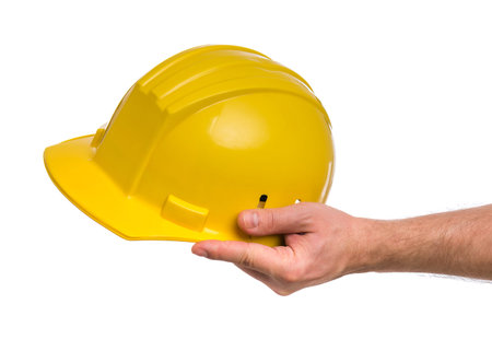 Male Hand with yellow safety helmet. Human Hand holding hard hat, Isolated on White Background.の写真素材