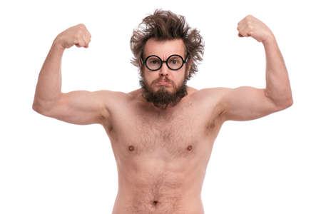 Crazy bearded Man with funny Haircut raised his hands and shows biceps. Naked strong guy flexing biceps and looking at camera. Handsome male isolated on white background.の写真素材