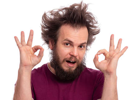 Portrait of handsome bearded man making Ok Gesture, isolated on white background. Happy crazy male smiling and giving OK sign. Caucasian man with funny haircut showing okay.の写真素材