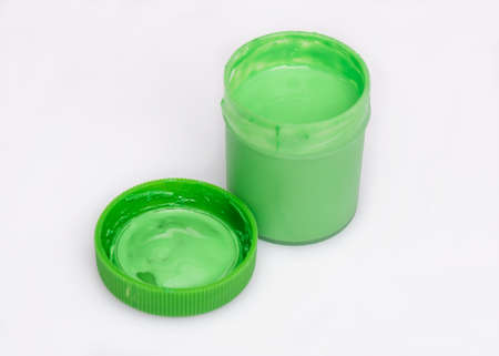 Opened green Gouache jar, on white background with copy space. Cans of different colors gouache paints.の写真素材