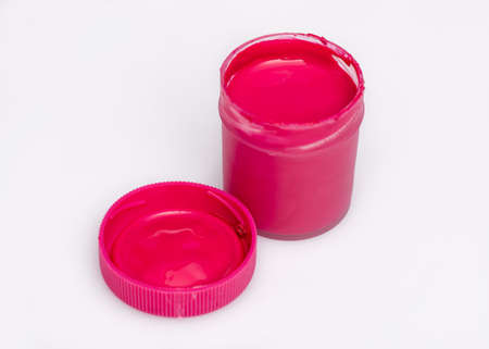 Opened red Gouache jar, on white background with copy space. Cans of different colors gouache paints.の写真素材
