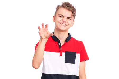 Funny teen boy trying to frighten someone with stretched hand. Emotional portrait of angry boy with hand up, isolated on white background. Negative human emotion, facial expression.の写真素材