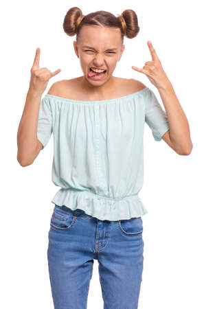 Funny teen girl making Rock Gesture, isolated on white background. Crazy teenager shows tongue and doing heavy metal rock sign. Problems of transitional age.の写真素材