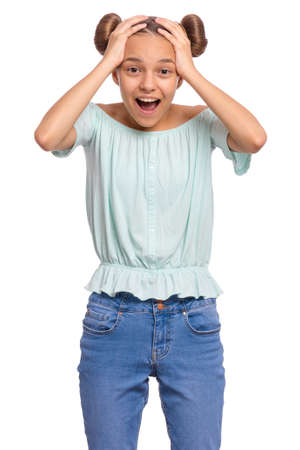 Portrait of surprised teen girl, isolated on white background. Funny child looking at camera in amazement, touching head with hands. Beautiful caucasian teenager, opening eyes and mouth with shock.の写真素材