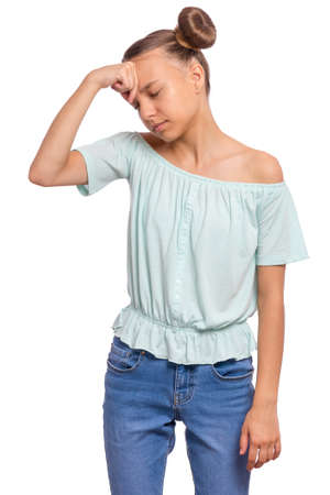 Portrait of tired teen girl touching head suffering headache. Sad teenager isolated on white background. Unhappy beautiful caucasian young teenager suffering from headache.の写真素材