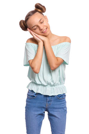 Portrait of teen boy sleeping tired or dreaming posing with hands together with closed eyes. Cute young caucasian teenager isolated on white background. Happy smiling child.の写真素材