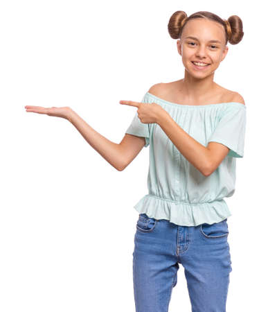 Portrait of teen girl pointing hands away at copyspace, isolated on white background. Beautiful caucasian young teenager smiling and attracted by attention pointing finger at something. Happy child.の写真素材
