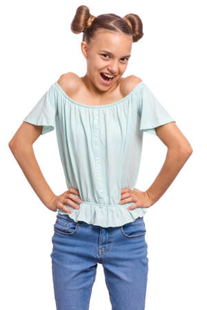 Portrait of happy teen girl with funny hairstyle, isolated on white background. Smiling child with hands on waist looking at camera. Beautiful young caucasian teenager.の写真素材