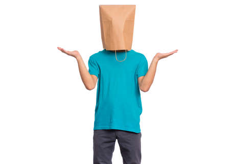 Portrait of teen boy with paper bag over head showing helpless gesture with hands - I do not know. Teenager cover head with bag, isolated on white background. Child making helpless sign or choice.の写真素材