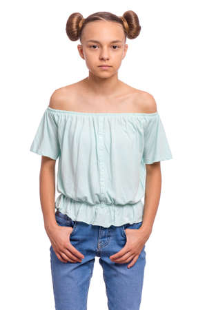 Portrait of teen girl with funny hairstyle, isolated on white background. Cute child putting hands in pockets and looking at camera. Beautiful young caucasian teenager. Front view.の写真素材