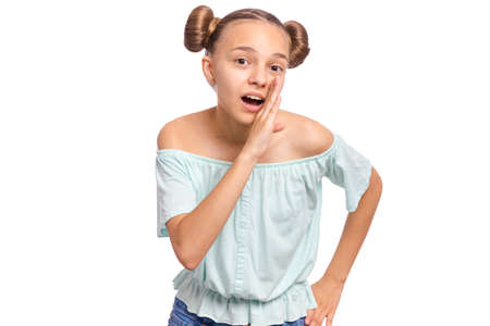 Portrait of teen girl holds her hand near her mouth and talk something, isolated on white background. Cute caucasian young teenager whispering gossip.の写真素材