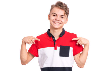 Portrait of handsome teen boy pointing oneself, isolated on white background. Happy smiling child looking at camera. Emotions and signs concept. Young student points fingers at himselfの写真素材