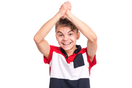 Portrait of teen boy happy and excited expressing winning gesture. Successful and celebrating victory, triumphant child making win sign. Beautiful caucasian teenager, isolated on white background.の写真素材