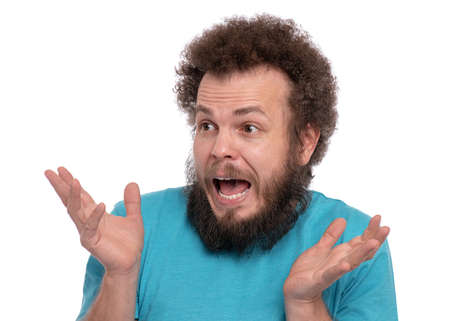 Portrait of bearded man with funny curly hair, isolated on white background. Surprised or Shocked guy looking away, keeping mouth open. Emotions and signs concept.の写真素材