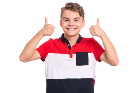 Portrait of teen boy making thumbs up gesture, isolated on white background. Handsome young teenager smiling and showing success sign. Happy cute caucasian child looking at camera.の写真素材