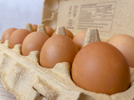 Brown eggs in cardboard egg box. Raw organic chicken eggs in carton.