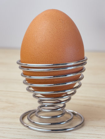 Fresh boiled eggs in egg cup for breakfast on wooden table at kitchen.の写真素材