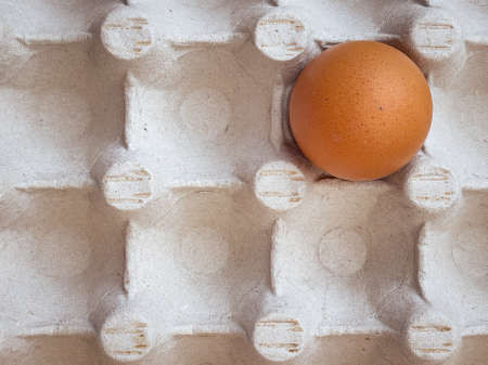 Brown eggs in cardboard egg box. Top view of raw organic chicken eggs in carton.の写真素材