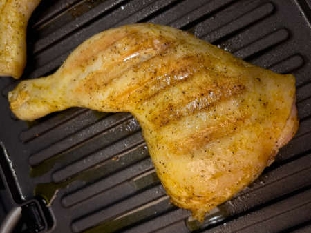 Homemade grilled chicken thighs. Preparing chicken meat on electric grill.の写真素材