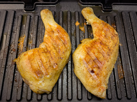 Homemade grilled chicken thighs. Preparing chicken meat on electric grill.の写真素材
