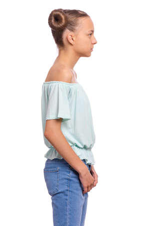 Profile portrait of serious young girl, isolated over white background. Teen girl looking away.の写真素材