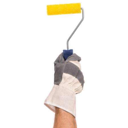 Handyman with work glove holding a paint tool. Male hand wearing working glove with paint roller isolated on white background.の写真素材