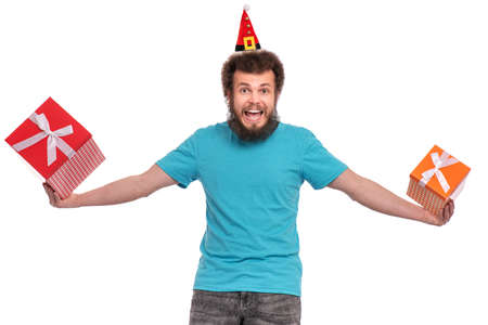 Cheerful bearded man wear Santa Claus hat holding Christmas present. Happy male with gift boxes isolated over white background.の写真素材