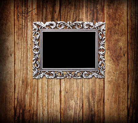 Empty silver frame, on a wood wallの写真素材