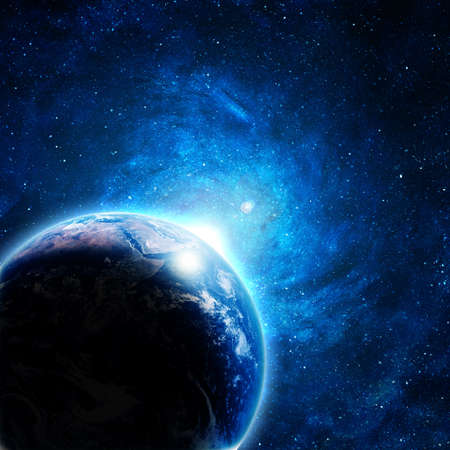 blue earth in space with rising sunの写真素材