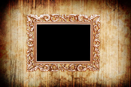 ancient style golden photo image frame on wood backgroundの写真素材