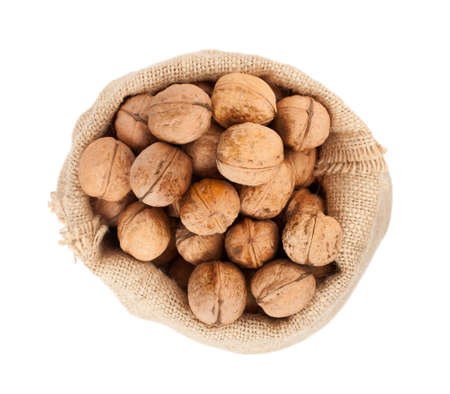 Burlap sack full of whole walnuts isolated on white backgroundの写真素材