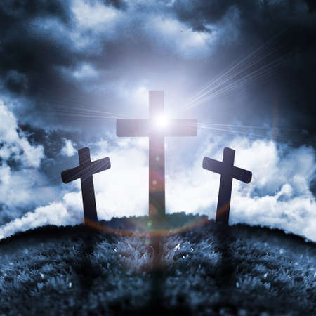 Silhouette of three crosses on a hill with a moon behind themの写真素材
