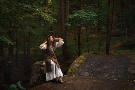 a young witch in an autumn forestの写真素材
