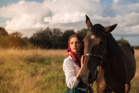 beautiful gypsy with a horse in the field in summerの写真素材