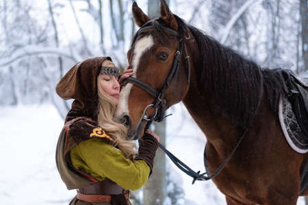 female magician with a horse in the winter forestの写真素材