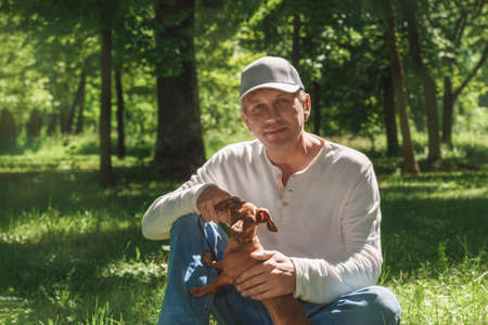 Young guy with retriever on walk in summer parkの写真素材