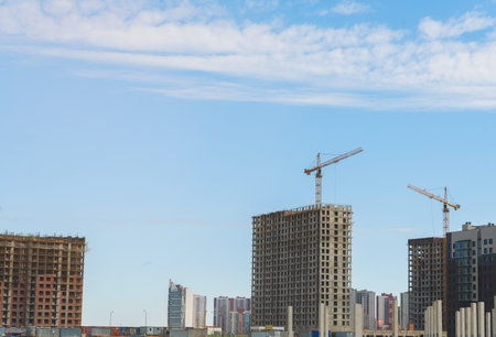 Crane and building under construction against blue sky
