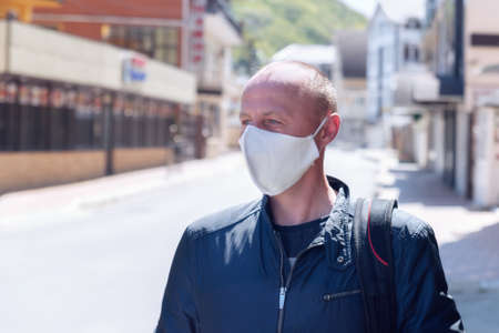 A man in a black medical mask on the street. A man in a medical mask. Quarantine. Self isolation.の写真素材