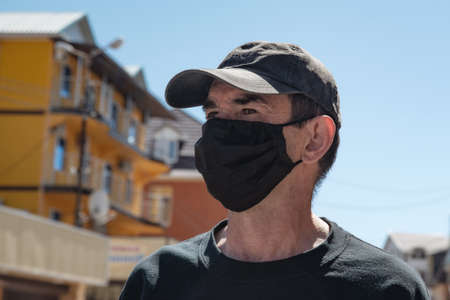 A man in a protective mask on an empty street. Quarantine and isolationの写真素材