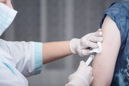 Close-up hands, nurses are vaccinations to patients using the syringe. Are treated by the use of...