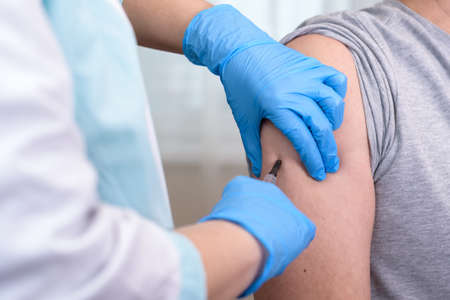 Close Up Of Unrecognizable Doctor Doing Vaccination To Elderly Man, Copy Spaceの写真素材