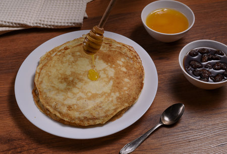 top view of pancakes on white dish and honey jarの写真素材