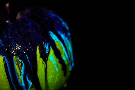 Red apple with dripping blue paint. Minimal food concept.の写真素材