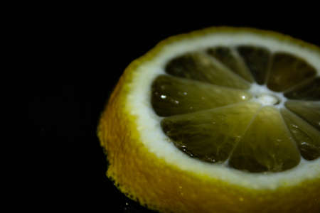 Branch with the ripening wet lemon on a black backgroundの写真素材
