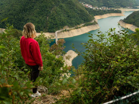 The girl admires the landscape on Piva lake in the Durmitor National Park. Montenegroの写真素材