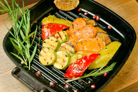 Assorted grilled vegetables with fried lemon. On a wooden trayの写真素材